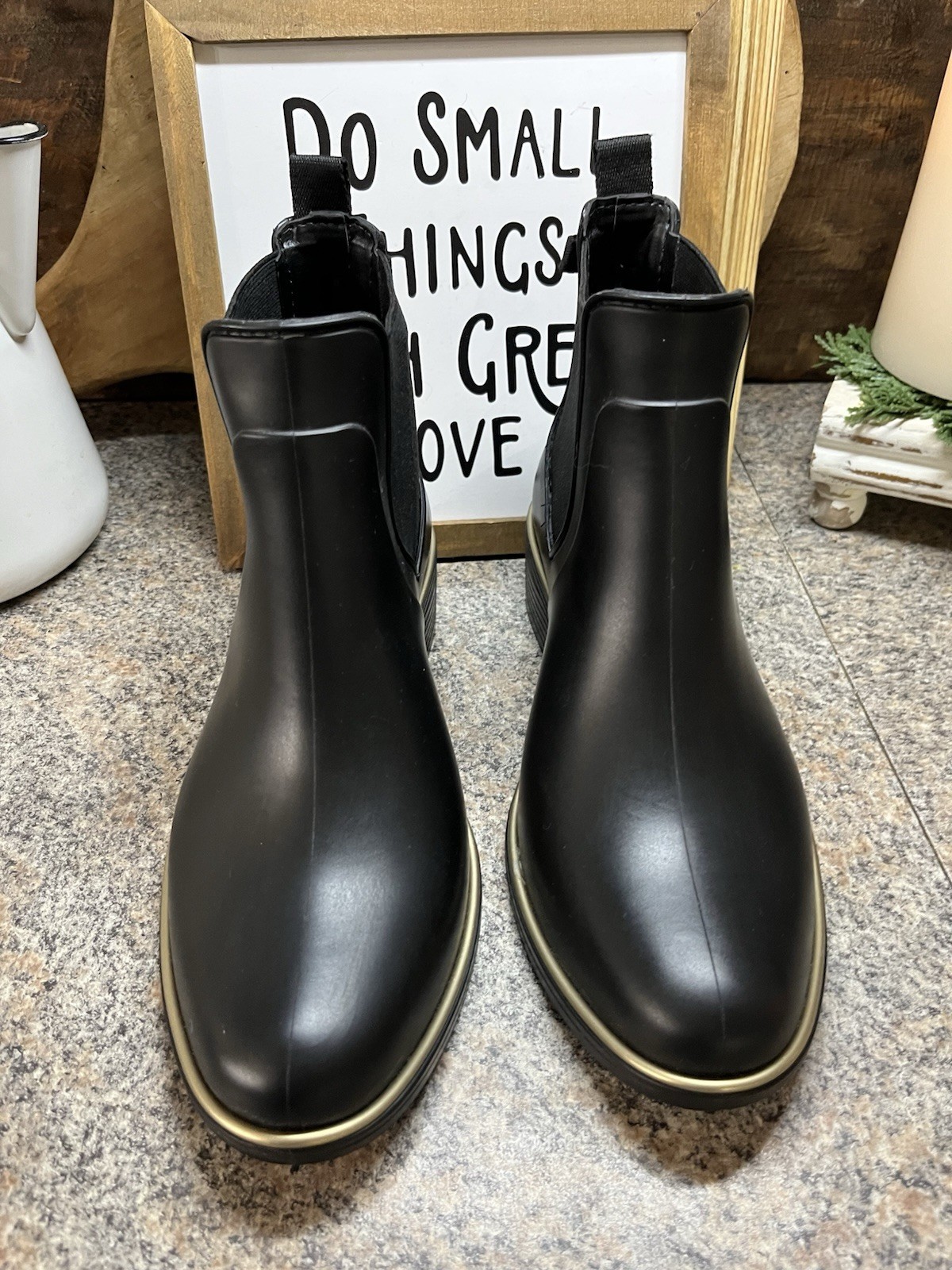 Kate Spade New York black Chelsea rain boots feature a distinctive gold trim